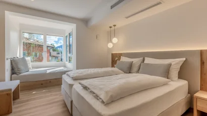 Modern bedroom with large bed and window seat with cushions