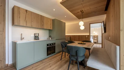 Modern kitchen and dining area with wood paneling and bench seating