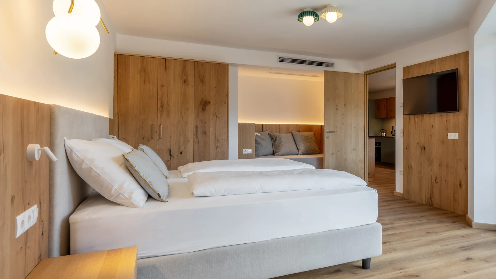 Modernes Hotelzimmer mit Doppelbett, Holzmöbeln und Flachbildfernseher