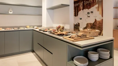 Buffet with bread, cold cuts, and fruit in modern breakfast room