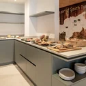 Buffet with bread, cold cuts, and fruit in modern breakfast room